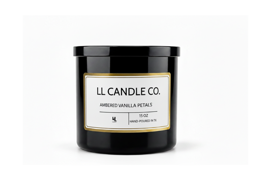 A 15 oz black glass jar candle by LL Candle Co. with a white label and gold border, reading 'Ambered Vanilla Petals'.