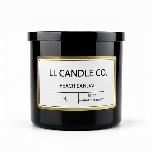 A black glass jar candle with a white label and gold border, reading 'LL CANDLE CO. BEACH SANDAL' on a clean white background.