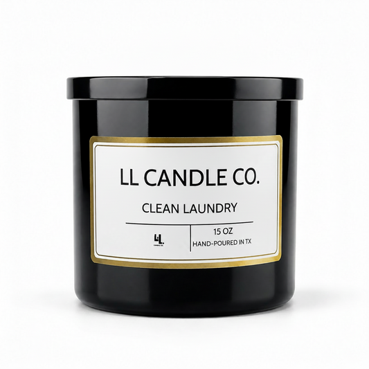 A black glass jar candle with a white label and gold border, labeled 'LL CANDLE CO. CLEAN LAUNDRY' on a clean white background.